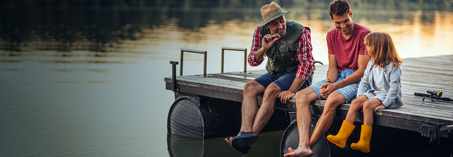 Family sitting on pier on lake